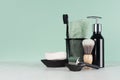 Stylish bathroom interior with black shaving accessories on green  wall, white table - razor, toothbrush, towel, soap, shave brush Royalty Free Stock Photo