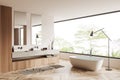 Stylish bathroom interior with tub and washbasin, panoramic window