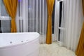 Stylish bathroom with jacuzzi and large french windows
