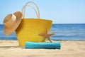 Stylish beach accessories on sand near sea Royalty Free Stock Photo