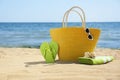 Stylish beach accessories on sand near sea Royalty Free Stock Photo