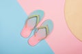 Stylish beach flip-flops and sun hat on pink and blue pastel background, top view. Summer concept with copy space. Royalty Free Stock Photo