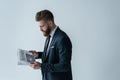 Stylish bearded businessman reading newspaper