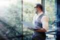 Stylish Bearded Businessman Wearing Glasses White Shirt Waistcoat Holding Modern Laptop Hands Looking Panoramic Window Royalty Free Stock Photo