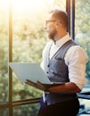 Stylish Bearded Businessman Wearing Glasses White Shirt Waistcoat Holding Modern Laptop Hands Looking Panoramic Window Royalty Free Stock Photo