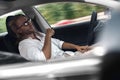 Mode of Transport. Bearded man with long hair in sunglasses traveling sitting inside electric car driving on autopilot Royalty Free Stock Photo