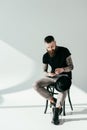 stylish bearded tattooed man using smartphone