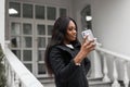 Stylish beautiful african business woman with smartphone making video call in the city. Girl taking a selfie Royalty Free Stock Photo