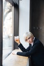 Stylish beautiful blonde drinking at the windowsill Royalty Free Stock Photo