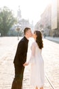 Stylish beautiful couple Asians newlyweds walking on the streets of old city, kissing, on a sunny day of their wedding