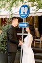 Stylish beautiful couple Asians newlyweds walking on a sunny day of their wedding, standing, holding hands near the