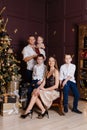 Stylish beautiful family in smart clothes at the New Year photo shoot. dark studio design