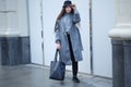 Fashionable young woman in coat and hat posing on the street. The girl walks around the city. The woman went shopping Royalty Free Stock Photo