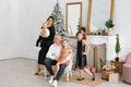 A stylish beautiful large family celebrates Christmas and New Year in the living room in their house near the Christmas tree Royalty Free Stock Photo