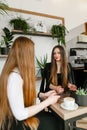 Stylish, beautiful, office workers in formal wear in a cozy cafe, drinking coffee and chatting in the break. Meeting of two Royalty Free Stock Photo