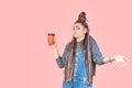 Stylish beautiful young woman holding disposable cup of paper coffee. Surprise on face and arms spread. Concept for advertising Royalty Free Stock Photo