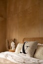 Stylish Bedroom corner with rattan headboard bed and soft pillow decoration with  with plywood wall on the background / cozy Royalty Free Stock Photo