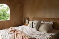 Stylish Bedroom corner with rattan headboard bed and soft pillow decoration with  with plywood wall on the background / cozy Royalty Free Stock Photo