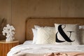 Stylish Bedroom corner with rattan headboard bed and soft pillow decoration with  with plywood wall on the background / cozy Royalty Free Stock Photo