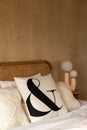 Stylish Bedroom corner with rattan headboard bed and soft pillow decoration with  with plywood wall on the background / cozy Royalty Free Stock Photo