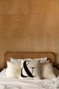 Stylish Bedroom corner with rattan headboard and bed with soft white pillows setting with plywood wall on the background / cozy in Royalty Free Stock Photo