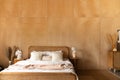 Stylish Bedroom corner with rattan headboard and bed with soft white pillows setting with  plywood wall on the background / cozy Royalty Free Stock Photo