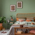 Stylish bedroom interior design with mock up poster frame, bamboo bed, night table, plants, folding screen and creative home Royalty Free Stock Photo