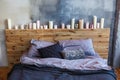 Stylish bedroom in loft style with grey colors and many candles.