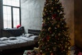 Stylish bedroom with modern bed and large Christmas tree with a Royalty Free Stock Photo