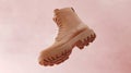 Brown Combat Boot Floats Against a Light Pink Background in a Studio Setting Royalty Free Stock Photo