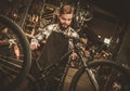 Stylish bicycle mechanic doing his professional work in workshop. Royalty Free Stock Photo