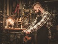 Stylish bicycle mechanic doing his professional work in workshop. Royalty Free Stock Photo