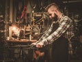 Stylish bicycle mechanic doing his professional work in workshop.