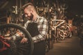 Stylish bicycle mechanic doing his professional work in workshop. Royalty Free Stock Photo