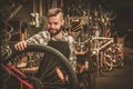 Stylish bicycle mechanic doing his professional work in workshop Royalty Free Stock Photo