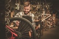 Stylish bicycle mechanic doing his professional work in workshop