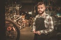 Stylish bicycle mechanic doing his professional work in workshop