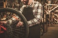 Stylish bicycle mechanic doing his professional work in workshop. Royalty Free Stock Photo