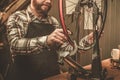 Stylish bicycle mechanic doing his professional work in workshop. Royalty Free Stock Photo