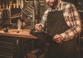 Stylish bicycle mechanic making notes in clipboard in his workshop.