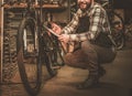 Stylish bicycle mechanic making notes in clipboard in his workshop.