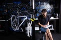 Stylish bicycle mechanic making notes in clipboard in workshop. theme small business selling, repair and service bicycles.