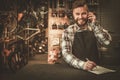 Stylish bicycle mechanic takes order by phone in his workshop.