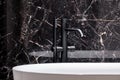 Stylish black bathtub faucet, close-up Royalty Free Stock Photo