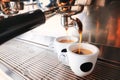 Stylish black espresso making machine brewing two cups of coffee, shooted in cafe. Royalty Free Stock Photo