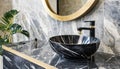 Stylish black marble round vessel sink and wall mounted faucet on stone wall. Interior design of modern bathroom Royalty Free Stock Photo