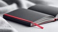A stylish black notebook with a red band and ribbon, open on a white surface. Royalty Free Stock Photo