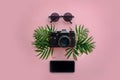 Stylish black photo camera with green palm leaves, sunglasses an Royalty Free Stock Photo