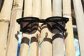 Stylish black sunglasses on bamboo background, elegant eyeglasses accessory isolated on wooden surface