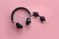 Stylish black sunglasses and headphones on pink background, flat Royalty Free Stock Photo